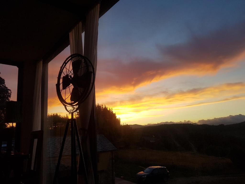 a view of a sunset from a window with a fan at Casa Do Ivi in Yermo