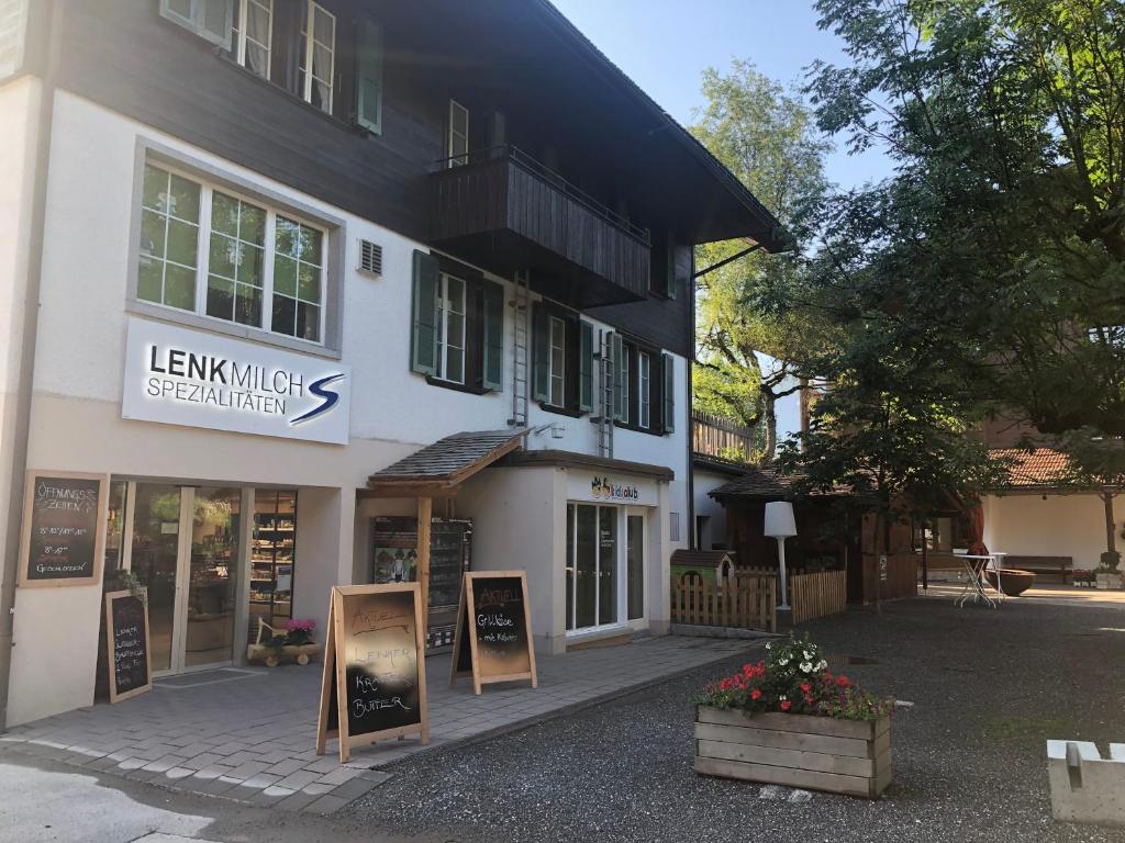 a large white building with signs in front of it at Hotel Krone Budget in Lenk