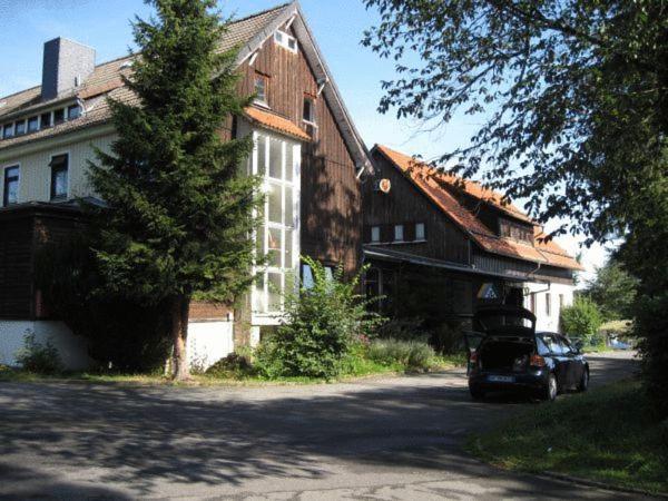 a car parked in front of a house at Hotel & Hostel Drei Bären in Altenau