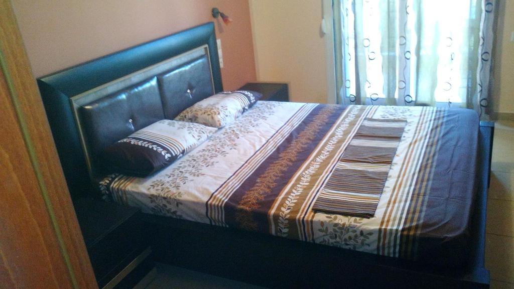 a bed with a wooden headboard and pillows on it at GIORGOS LUX APARTMENTS in Volos