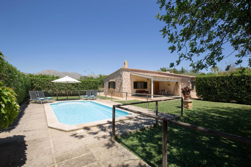 eine Villa mit einem Pool und einem Haus in der Unterkunft Villa Ca'n Lluis - La Goleta Hotel de Mar & Villas in Pollença
