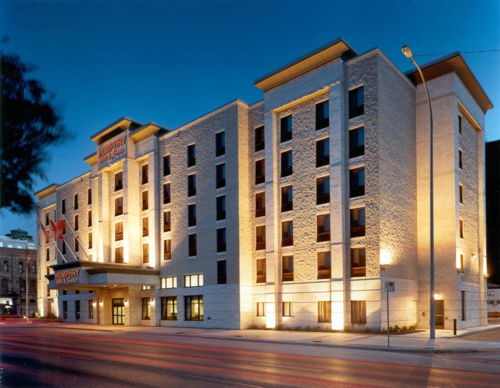 un grand bâtiment situé dans une rue de la ville la nuit dans l'établissement Humphry Inn and Suites, à Winnipeg