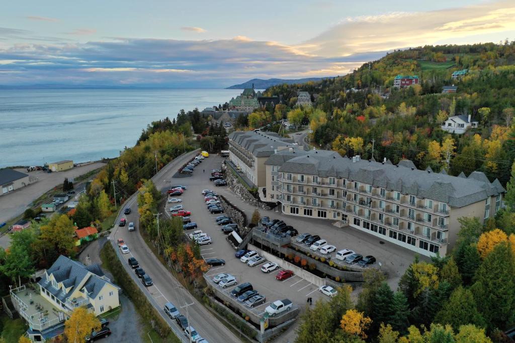 une vue aérienne sur un bâtiment avec un parking dans l'établissement Hôtel Le Petit Manoir du Casino, à La Malbaie