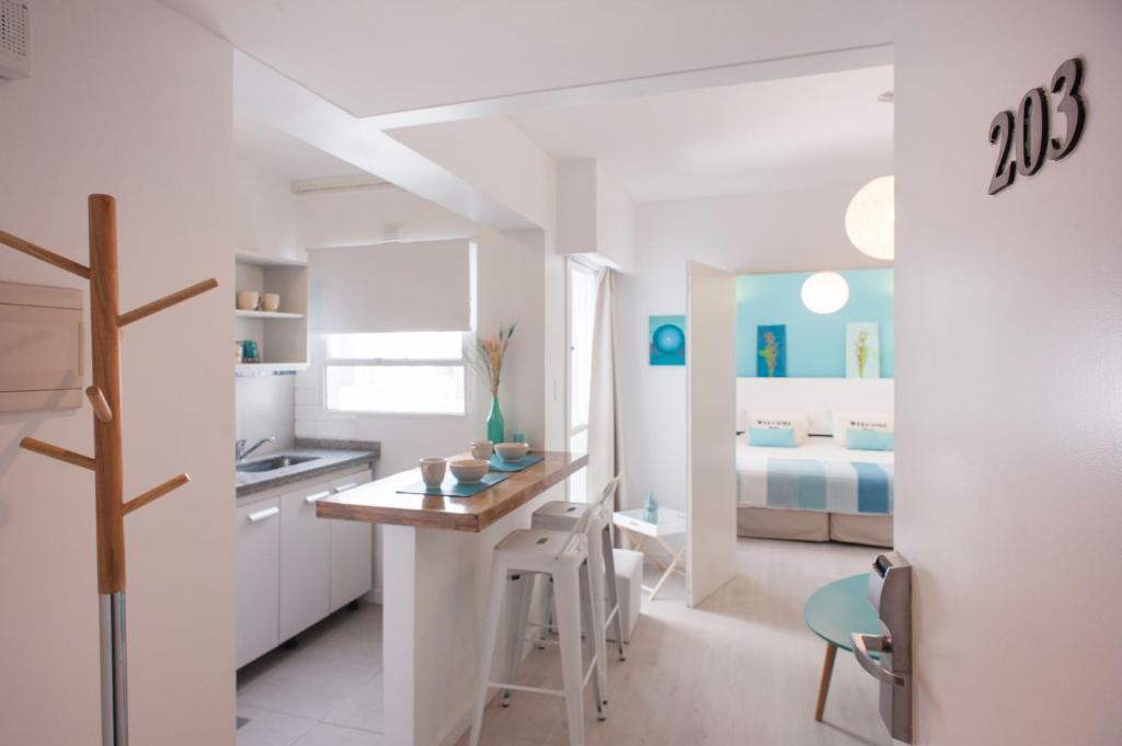 a white kitchen with a desk and a bed at Soho Point Central in Buenos Aires