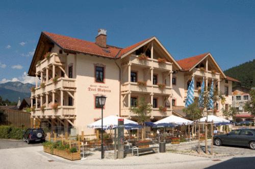 ein großes Gebäude mit Sonnenschirmen davor in der Unterkunft Hotel Drei Mohren in Garmisch-Partenkirchen