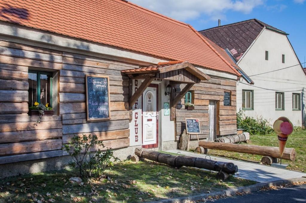 ein Holzgebäude mit einer Bank davor in der Unterkunft Rodinné apartmány Country golf club Střítež in Třebíč