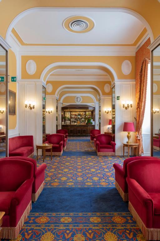 a waiting room with red couches and a lobby at Bettoja Hotel Massimo d'Azeglio in Rome
