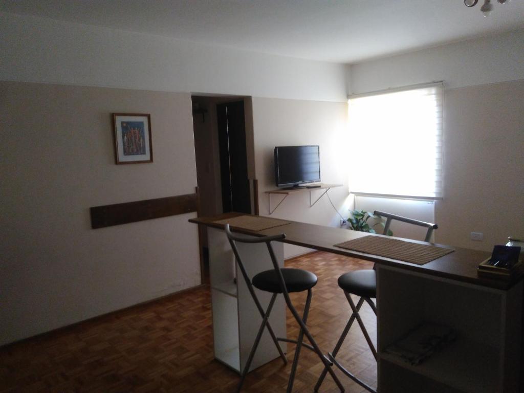 Cette chambre dispose d'un bureau, de deux chaises et d'une télévision. dans l'établissement Mendoza Capital Microcentro, à Mendoza