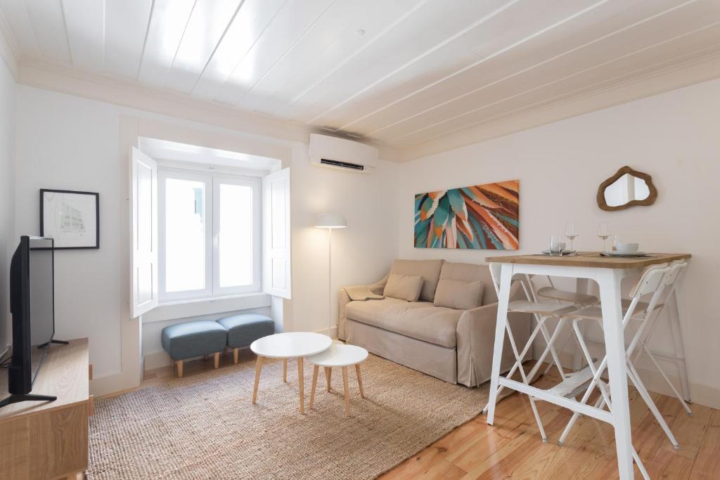 ein Wohnzimmer mit einem Sofa und einem Tisch in der Unterkunft FLH Anjos Lovely Apartment in Lissabon