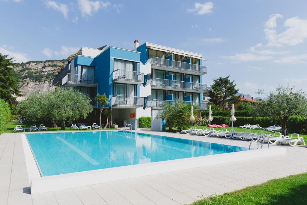 Villa con piscina frente a un edificio en Hotel Holiday Sport & Relax en Nago-Torbole