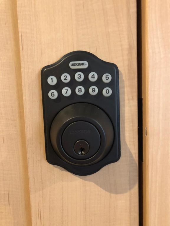a black remote control sitting on a wooden door at Oyado Zen in Kusatsu