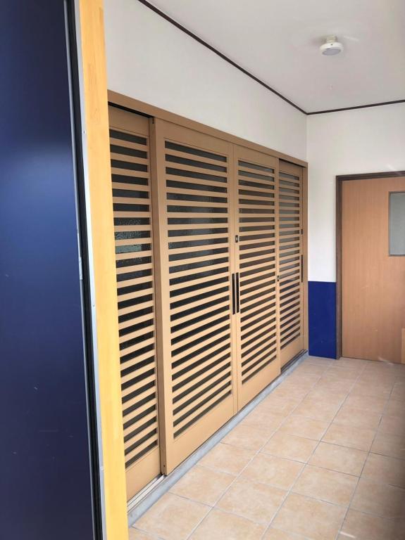a room with wooden closet doors and a tile floor at Oyado Zen in Kusatsu