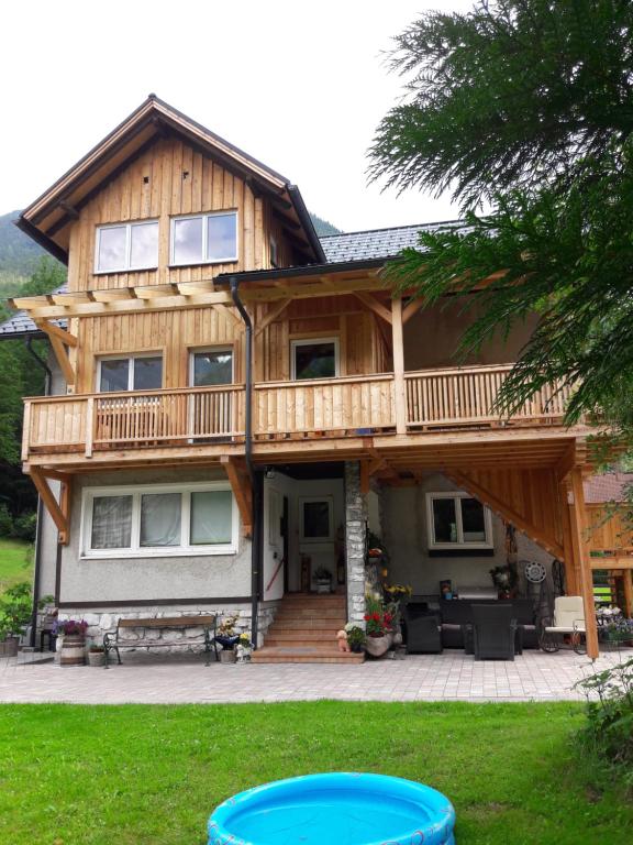 een groot houten huis met een groot terras bij Apartment Sandra in Obertraun