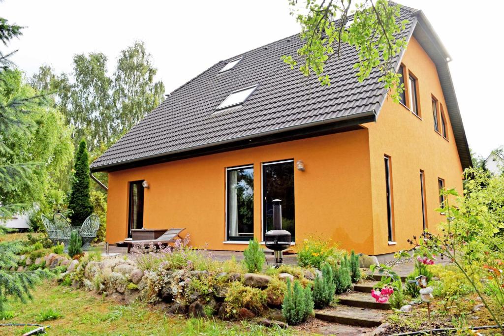 una casa naranja con un jardín delante de ella en ruhig gelegene Ferienwohnung am Ne, en Sandort