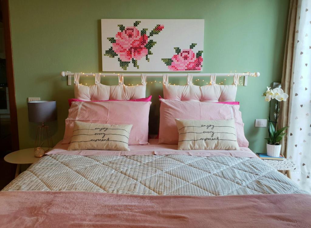 モンテスペルトリにあるAppartamento La Chiccheraのピンクベッド1台、枕が備わるベッドルーム1室が備わります。