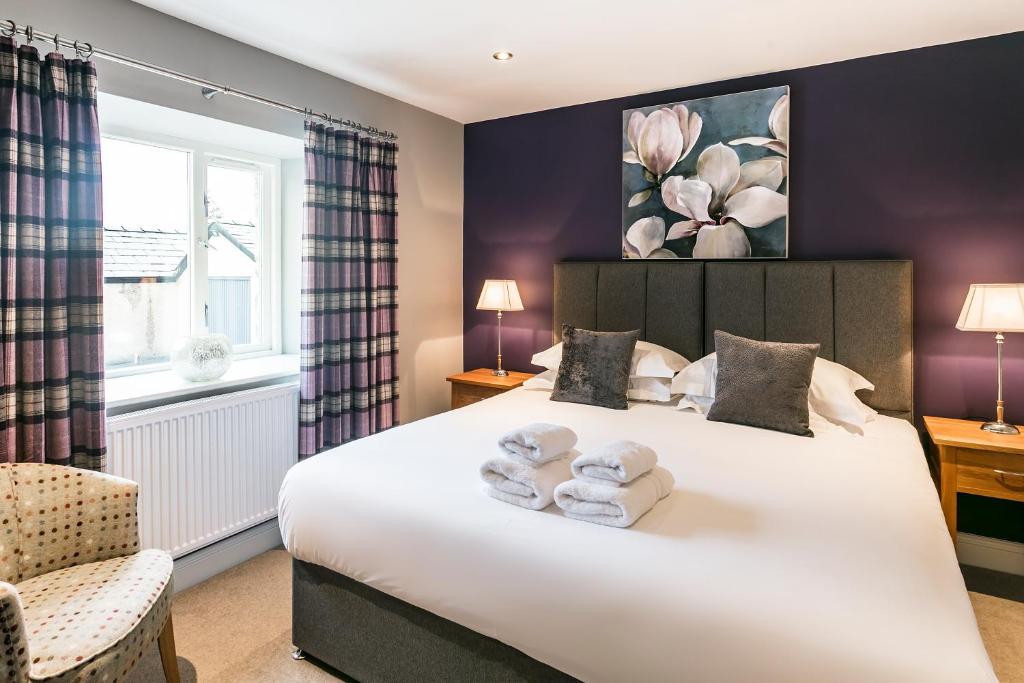 a bedroom with a large bed with towels on it at The Lodge @ Carus Green in Kendal