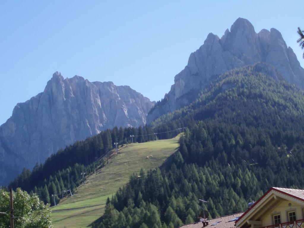 widok na pasmo górskie z drzewami i dom w obiekcie Tobià de Barat w mieście Pozza di Fassa