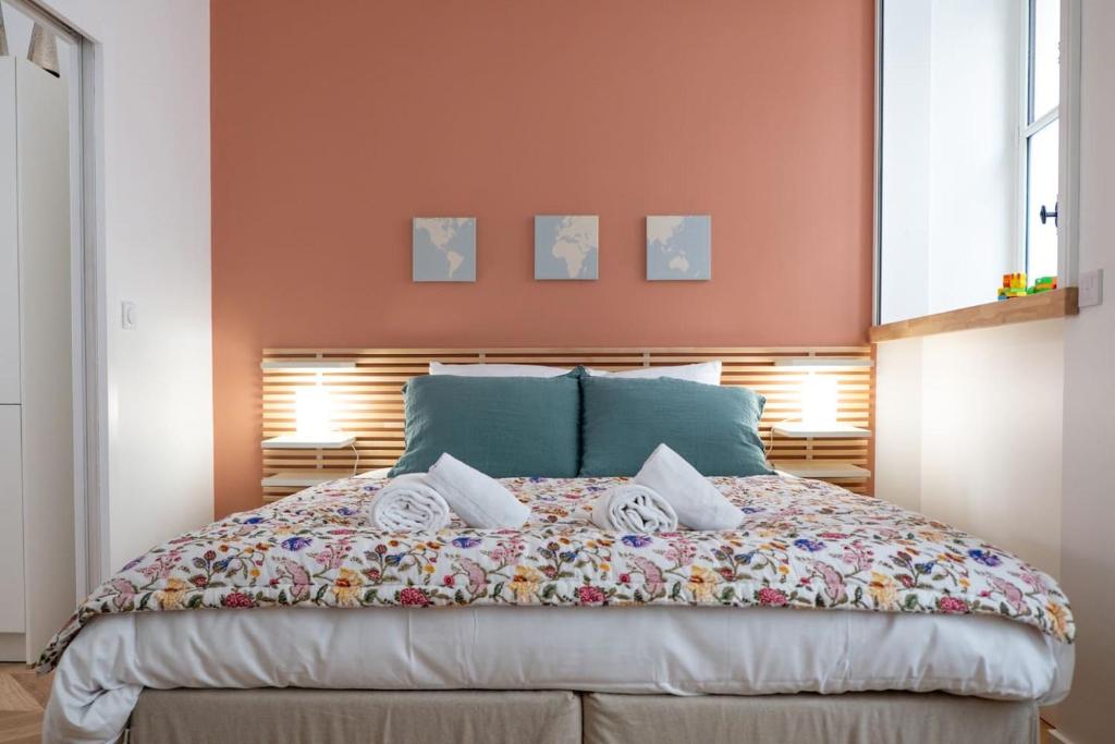 a bedroom with a large bed with orange walls at Hypercentre Appart 2 à4 pers Calme & Cosy avec Terrasse Privée in Nantes