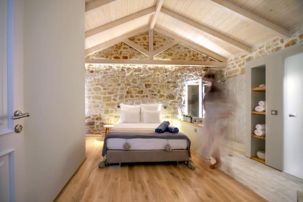 um quarto com uma cama e uma parede de pedra em Paxos Fairytales Lovenest 1 em Gaios