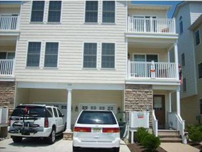 two cars parked in front of a house at Fountain Motel Townhouse with Shared Pool in Wildwood