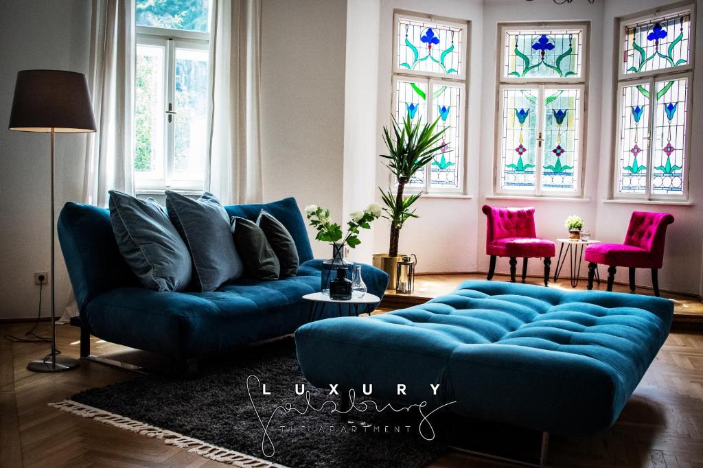 a blue couch in a living room with stained glass windows at Luxury apartments only for Business Travel in Salzburg