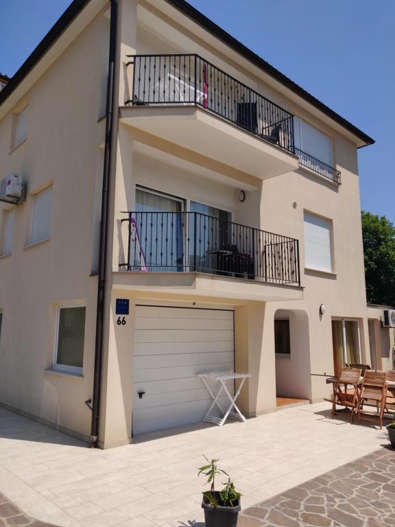 a house with a garage and a balcony at Apartment Greta,50 METERS TO THE BEACH in Banjole