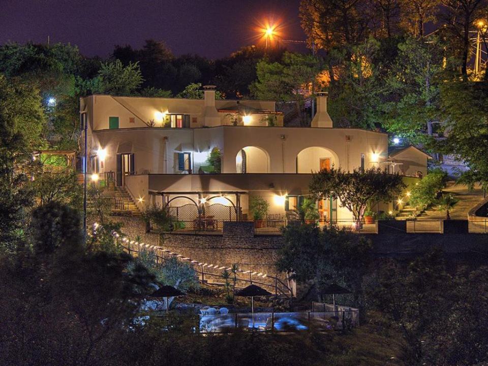 uma grande casa branca à noite com luzes em Villa Silvana em Fasano