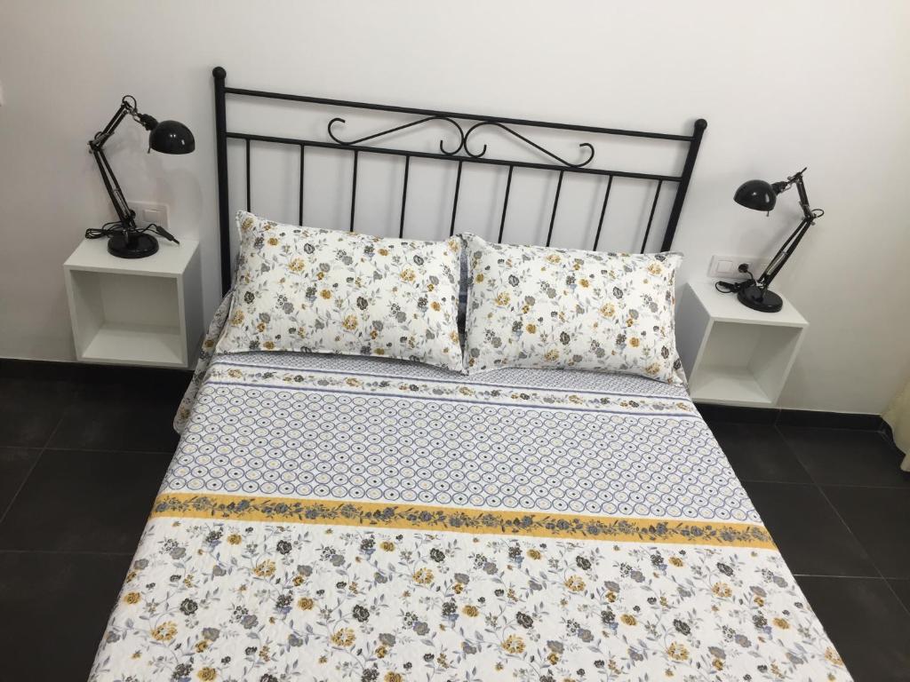 サン・セバスティアン・デ・ラ・ゴメラにあるApartamentos Hautacupercheのベッドルーム1室(ベッド1台、ランプ2つ、テーブル2台付)