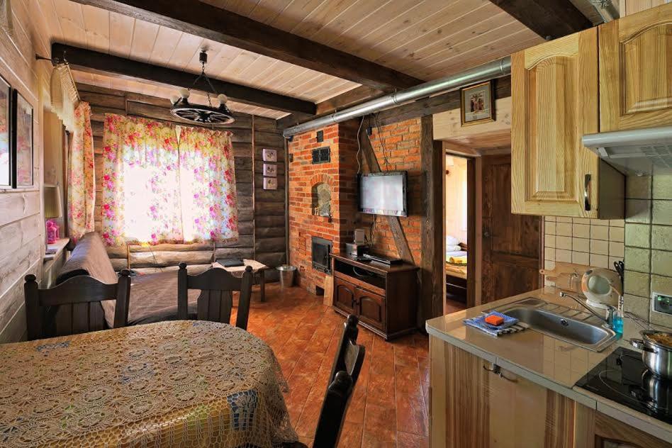 a kitchen and living room with a table and a kitchen gmaxwell gmaxwell gmaxwell at Mazury-dom in Świętajno