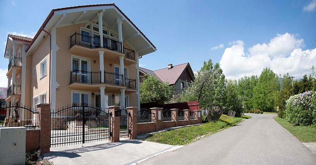 ein Haus mit einem Zaun davor in der Unterkunft Villa Butterfly in Nová Lesná