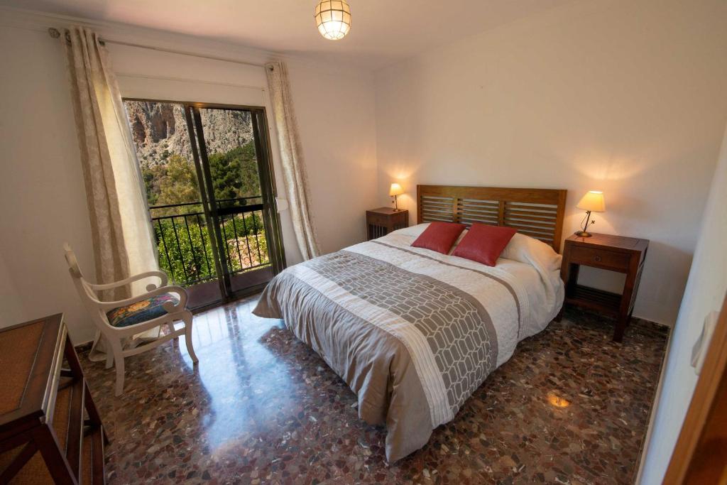 a bedroom with a bed and a large window at Casa El Chorro con magníficas vistas in El Chorro