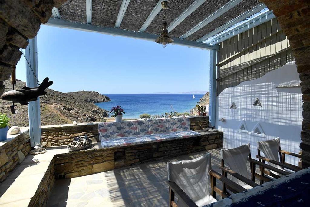 un balcón con un banco y vistas al océano en Tinos Traditional Sea Side Villa en Agios Romanos