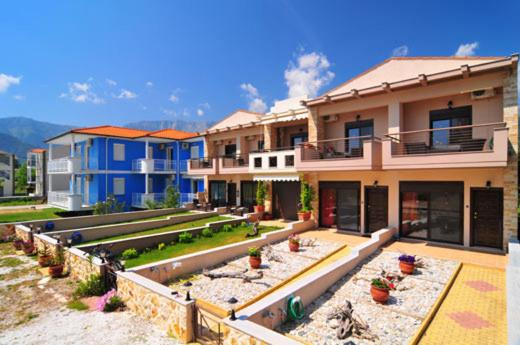 un grupo de casas con macetas delante de ellas en Golden Sunrise Apartments, en Chrysi Ammoudia