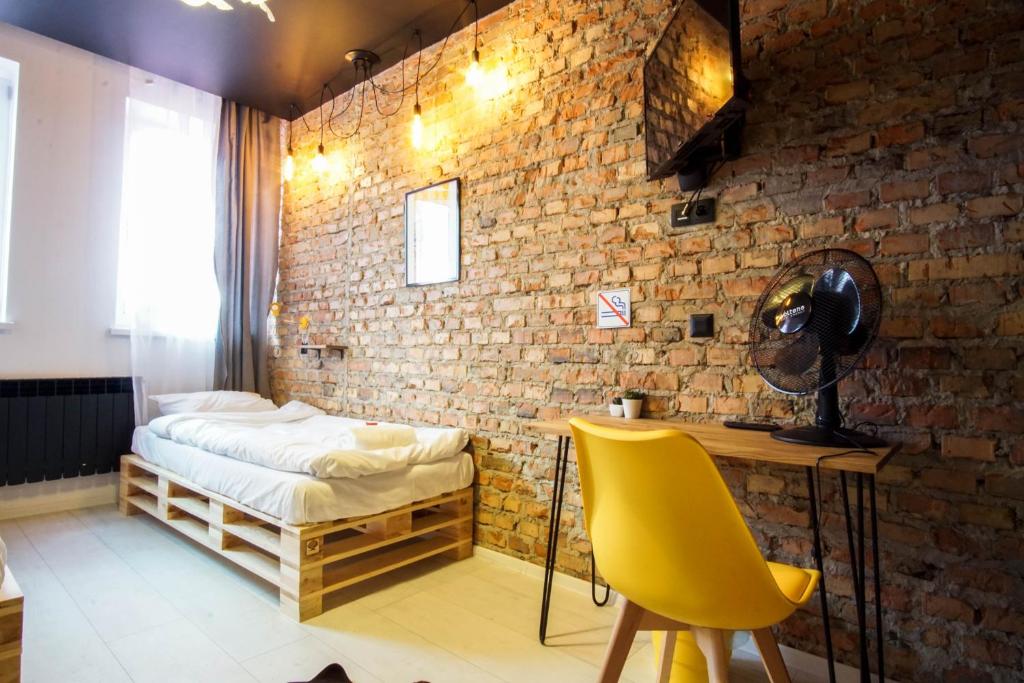 1 dormitorio con cama, escritorio y silla amarilla en Retro Apartments, en Rzeszów