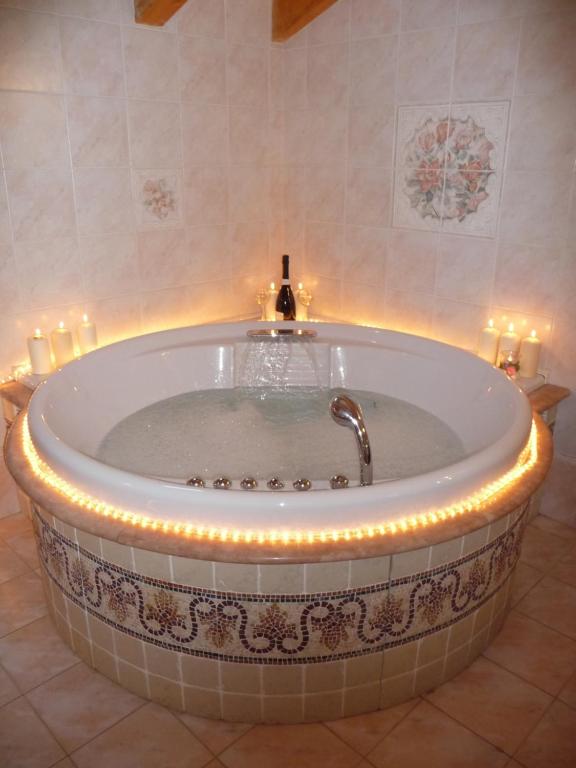 a bathroom with a tub with candles in it at La casa di Terlago in Terlago