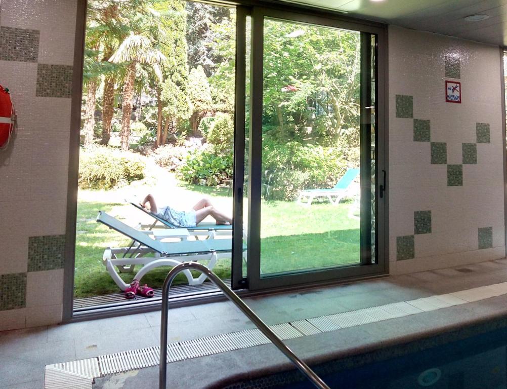 eine Person, die vor einem Fenster auf einer Bank liegt in der Unterkunft Hotel Guillem &amp; Spa in Encamp