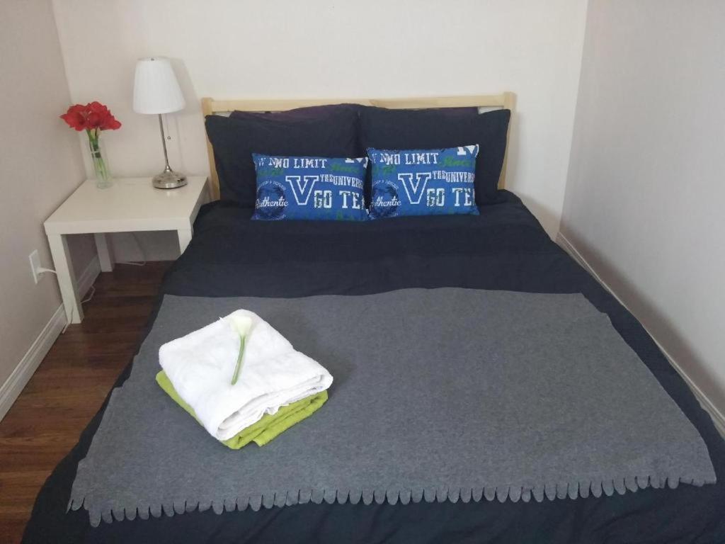 1 dormitorio con 1 cama con 2 toallas en Winnipeg Homestay, en Winnipeg