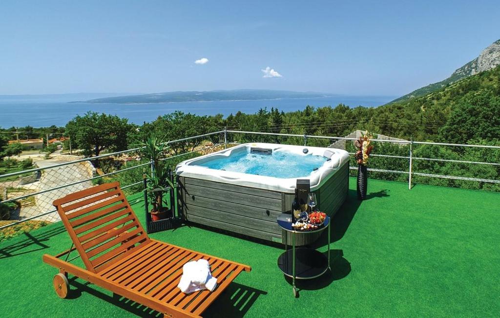 a hot tub on a balcony with a bench and a chair at VILLA BEST in Bast