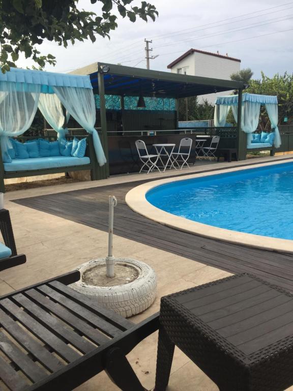 a bench sitting next to a swimming pool at Dardanos Pension in Hamidiye