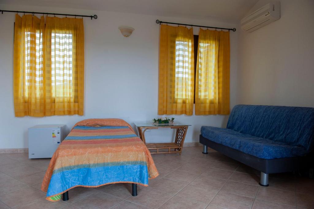 sypialnia z łóżkiem i niebieską kanapą w obiekcie Agriturismo B&B Casteldoria w mieście Santa Maria