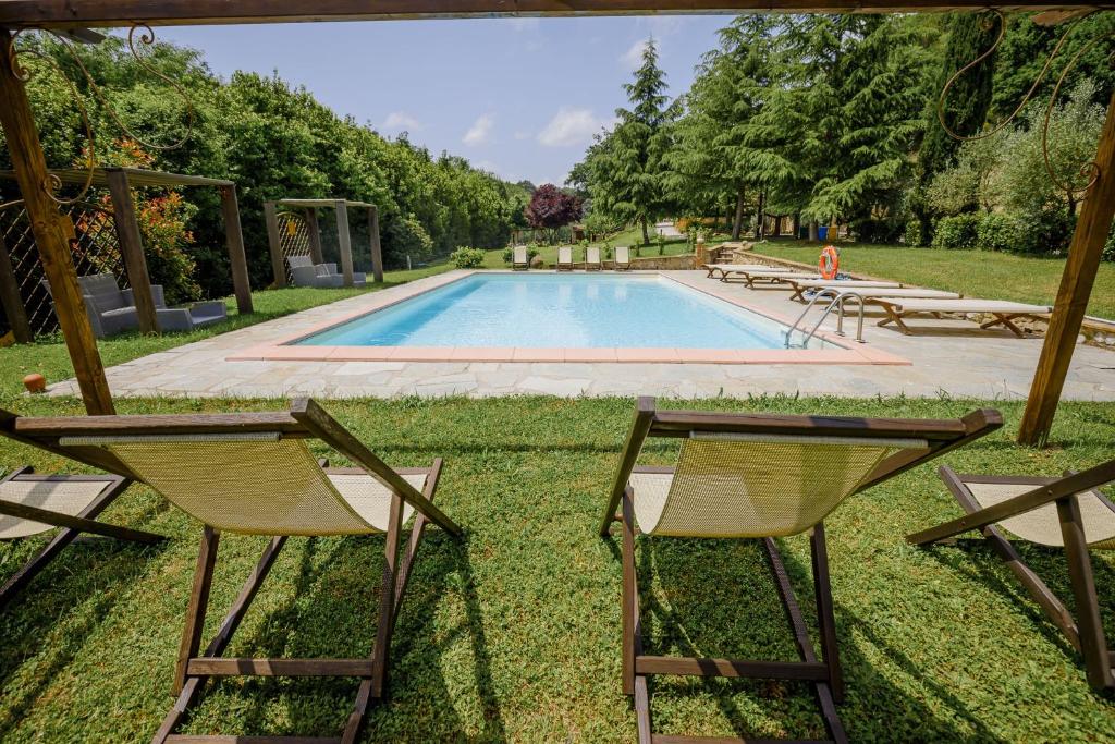 duas cadeiras e uma piscina num quintal em Villa Loghino em Volterra