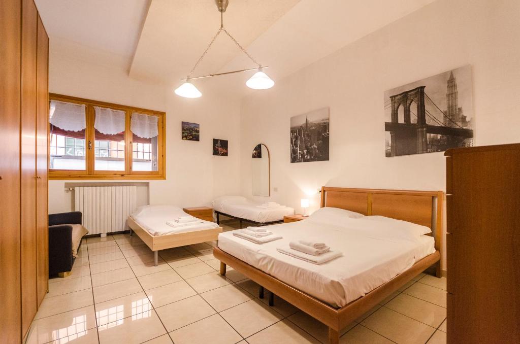 una camera con due letti e un divano in camera di Carro Apartment, in the Heart of Bologna a Bologna