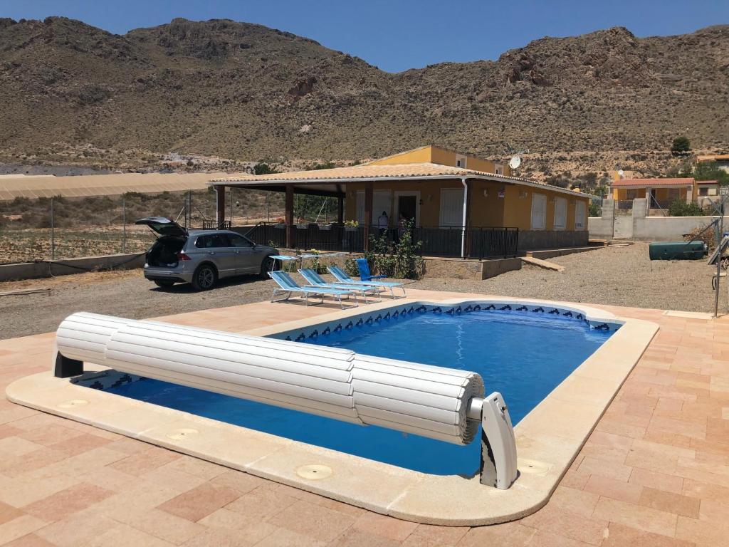 una gran piscina con sillas y una casa en Casa Rural Aguilas (Murcia), Venta San Felipe, en Águilas