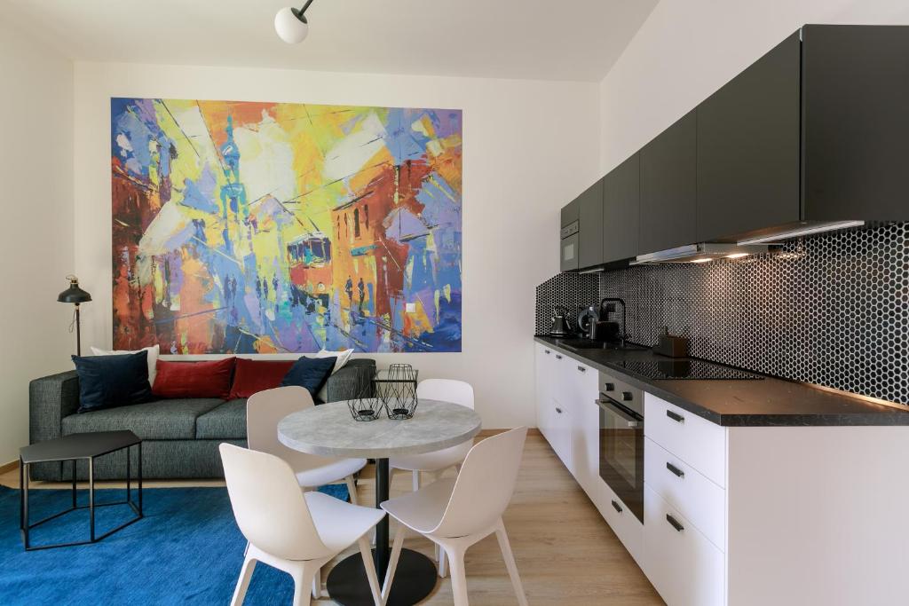 Una cocina y una sala de estar con una mesa y un sofá. en Avantgarde apartments, en Plzeň