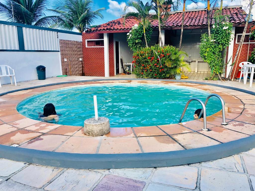 Dos perros están nadando en una piscina en Casa no Atalaia, en Salinópolis