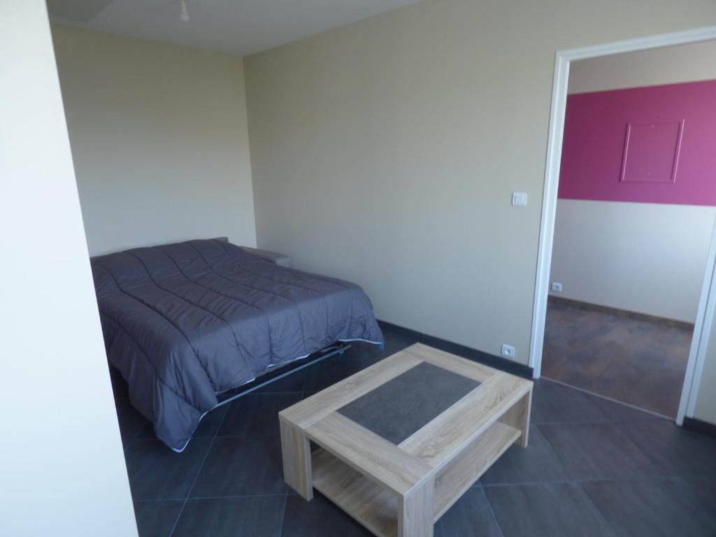 a bedroom with a bed and a coffee table at Appartement Plein Sud in Berck-sur-Mer