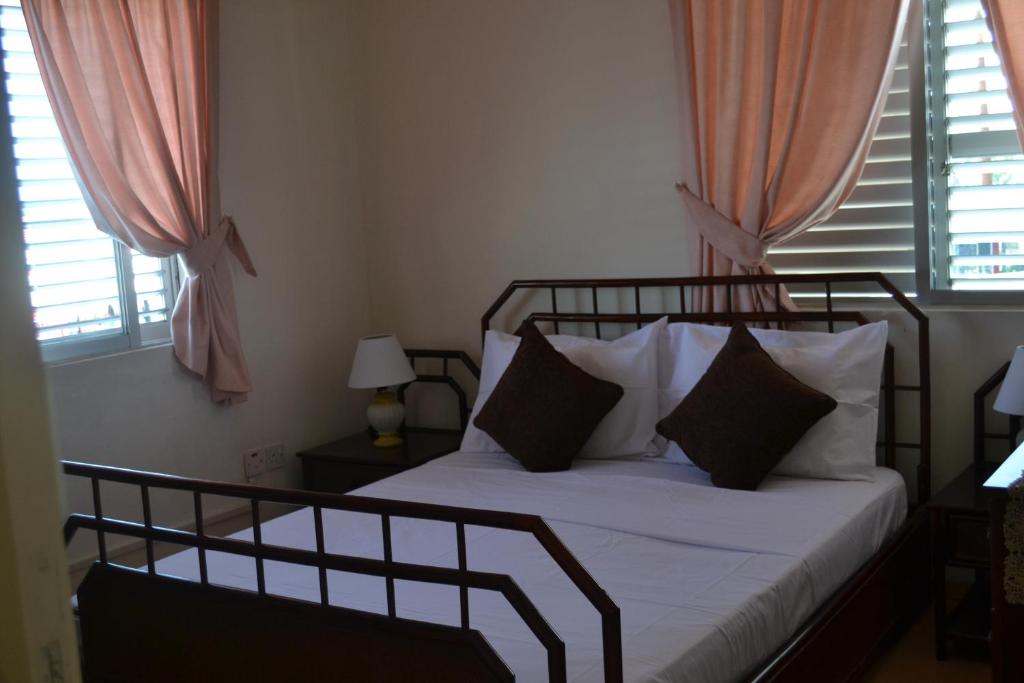 - une chambre avec un lit doté de draps et d'oreillers blancs dans l'établissement 13 Sandy Beach Mackenzie, à Larnaka