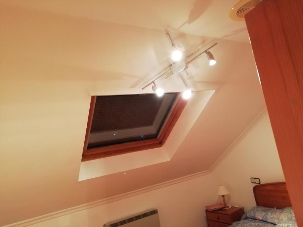 a flat screen tv on the ceiling of a bedroom at Duplex Álvaro cunqueiro, 1.3C1 in Foz