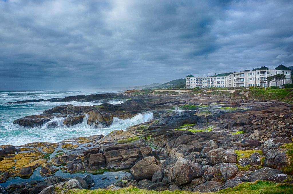 una vista del océano con olas chocando en las rocas en Overleaf Lodge and Spa en Yachats