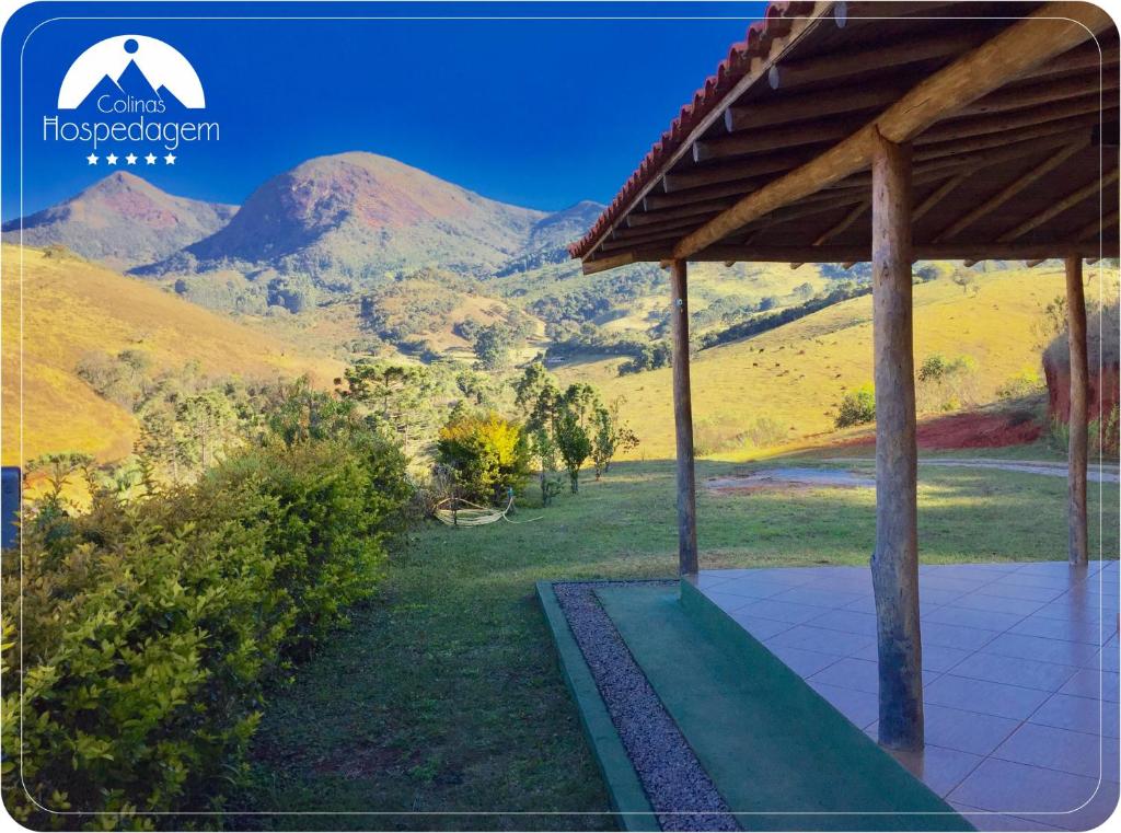 una foto de una casa con montañas en el fondo en Hospedagem Colinas, en Aiuruoca